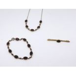 A group of 9ct garnet set jewellery comprising a brooch, a bracelet and a necklace (3).