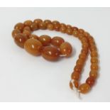 An amber necklace with graduated beads, approx 77.60gms.
