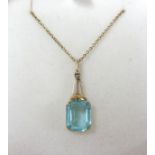 A 9ct pendant and chain set with an emerald cut blue stone.