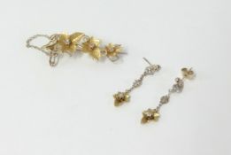 A 15ct diamond flower brooch and earrings.