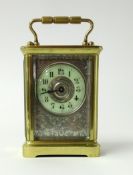 Carriage clock with circular dial and silvered plate, height 10cm.