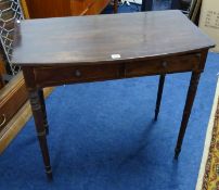 A Victorian mahogany side table fitted with two drawers on ring turned legs.