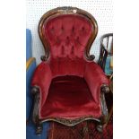 A Victorian mahogany framed upholstered and button backed armchair with carved frame.
