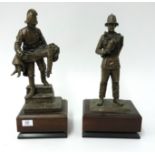 A pair of bronze effect fire fighting figures on wood plinth, height 73cm.