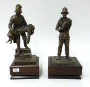 A pair of bronze effect fire fighting figures on wood plinth, height 73cm.