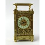A brass cased carriage clock the ornate case with fluted columns and pierced decoration on three