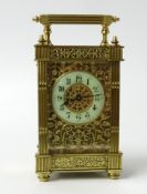 A brass cased carriage clock the ornate case with fluted columns and pierced decoration on three