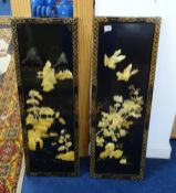 A pair of oriental lacquered wall panels decorated in relief with landscape, birds and flowers, 92 x