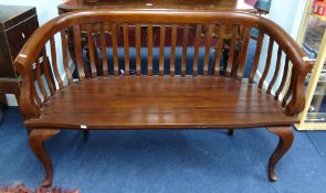 A wood framed two seater curved back bench.