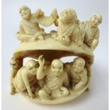 A Japanese Meiji Period ivory clam, carved with multiple figures, width 7.50cm.