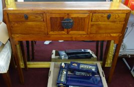 A narrow Chinese side table fitted with three drawers.