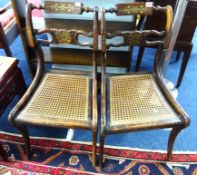 A pair of Regency side chairs with sabre legs, brass inlay and cane seats.