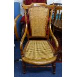 A elbow chair with cane back and seat on carved wood frame.