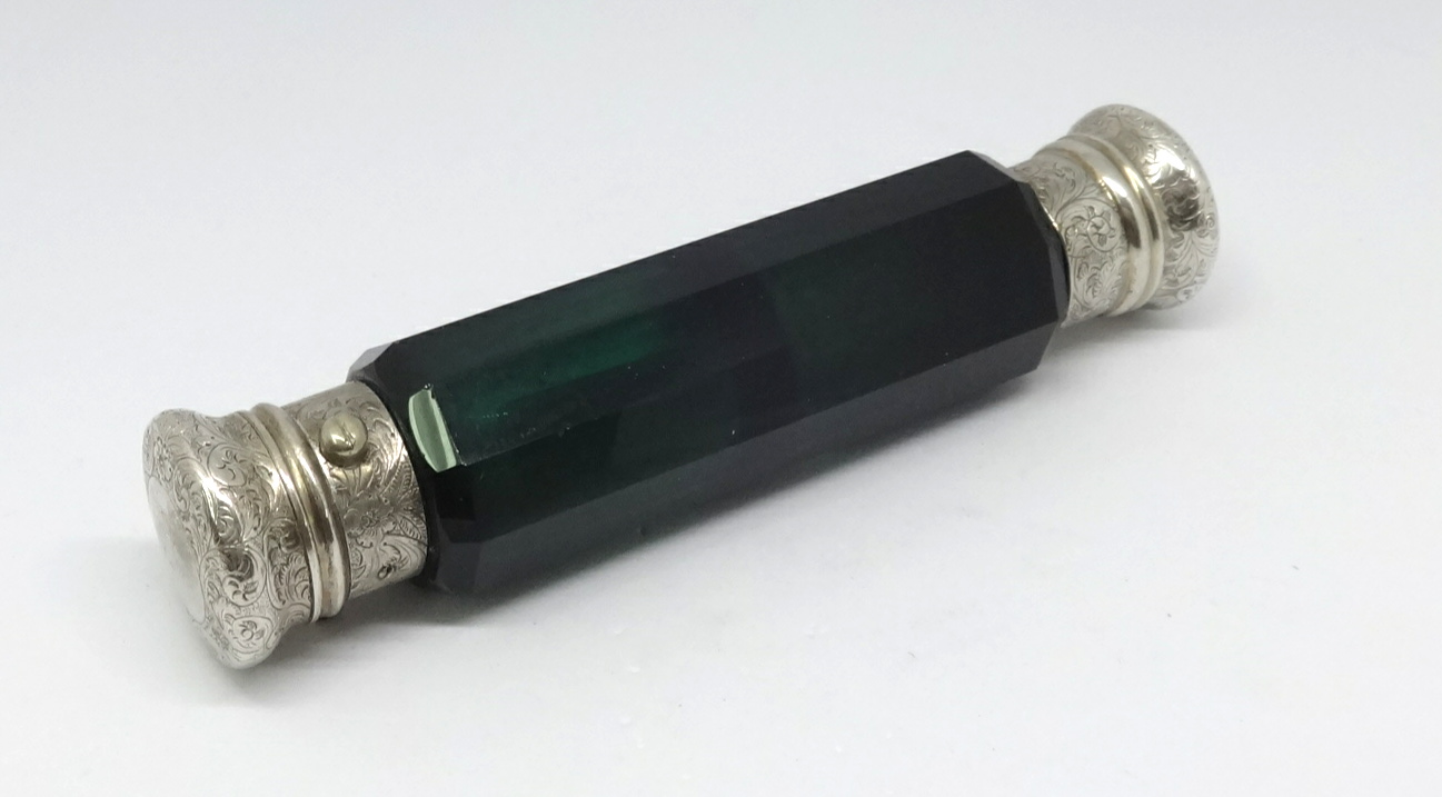 A Victorian green glass double end scent bottle with silver coloured tops.