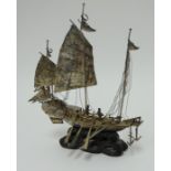 A Chinese silver boat model marked Tack Hing, silver on carved wood stand height 20cm.