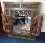 An ornate carved frame with a pair of doors containing a mirror, overall size 90 x 79cm.