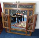 An ornate carved frame with a pair of doors containing a mirror, overall size 90 x 79cm.