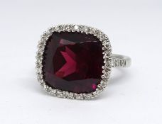 An 18ct white gold rubellite and diamond cluster ring, consisting of a large cushion cut rubellite