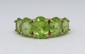 A 9ct five stone peridot ring size L.