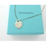 A Tiffany & Co. silver heart pendant, boxed.