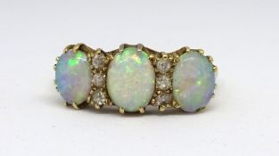 A 18ct opal six stone ring set within round small cut diamonds, size O.