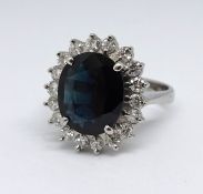 An 18ct sapphire and diamond cluster ring, size M.
