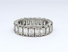 A fine diamond full eternity ring comprising 21 emerald cut diamonds of good quality, in a four claw