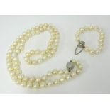 A long single row of 82 cultured pearls, (10-11mm), with a 14ct white gold diamond pave set ball