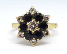 An 18ct sapphire and diamond cluster ring, set with a 4mm white diamond centre stone surrounded by