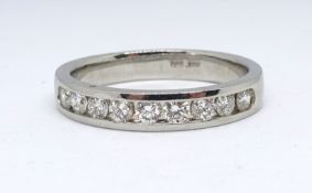 A platinum and diamond half band a channel set eternity ring, size R.