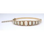 An antique yellow gold open diamond half snap hinged set bangle, possibly 15/18ct gold, set with