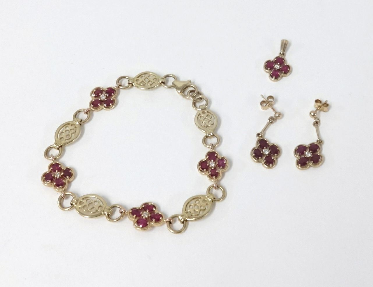 A 9ct gold suite of jewellery consisting of ruby and diamond flower cluster formation bracelet