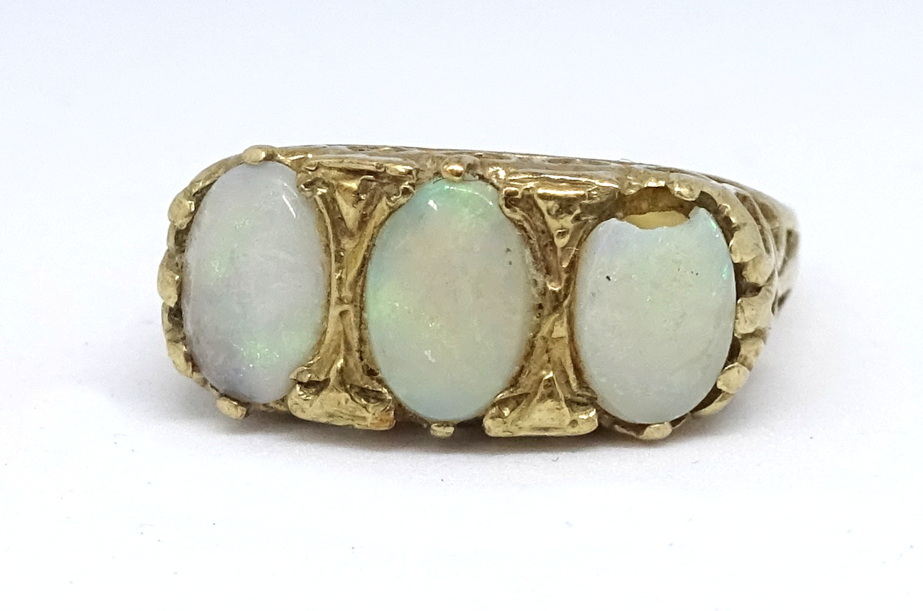 A 9ct opal three stone ring, size T.