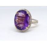 A 14ct yellow gold and diamond ring, set with an oval cut purple amethyst, approx. 6.92carat,