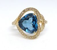 A 14ct yellow gold and diamond ring, set with a heart shaped blue topaz, approx. 3.54carat,