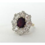 A good 18ct ruby and diamond cluster ring with central ruby stone and eight surrounding diamonds,