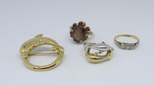 An 18ct three stone diamond ring, a dolphin pendant, a 14ct dolphin dress ring, and a 9ct smoky