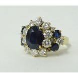 An 18ct sapphire and diamond cluster ring, set with 5 sapphires and an arrangement of diamonds.