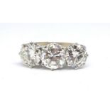 An 18ct fine diamond three stone ring, set with approx. 4 carats of diamonds, shank marked LJW, size