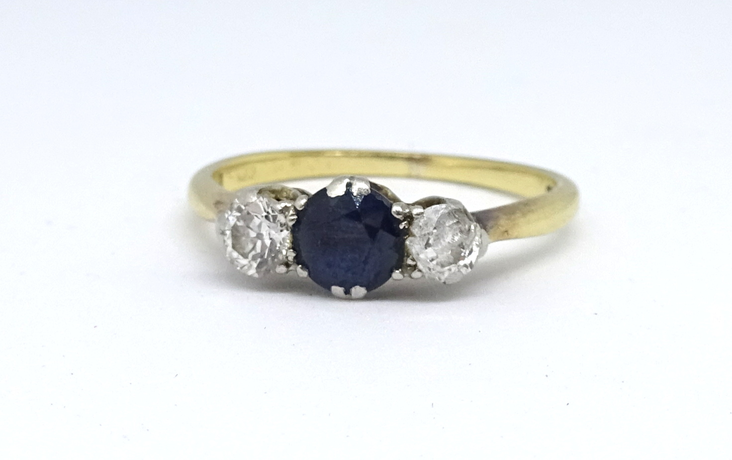 An 18ct sapphire and diamond three stone ring, size N.