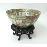 A 19th century Cantonese porcelain bowl, decorated with birds and trees on a carved hard wood stand,