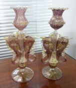 A pair of Venetian fish emblem glass candlesticks, decorated in purple with gold flecks, height