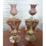 A pair of Venetian fish emblem glass candlesticks, decorated in purple with gold flecks, height
