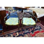 A pair of reproduction Regency style black lacquer and gilt framed elbow chairs with cane seats