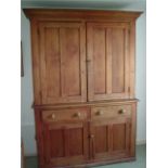An old pine housekeepers cupboard, upper section fitted with two cupboards, the base fitted with two