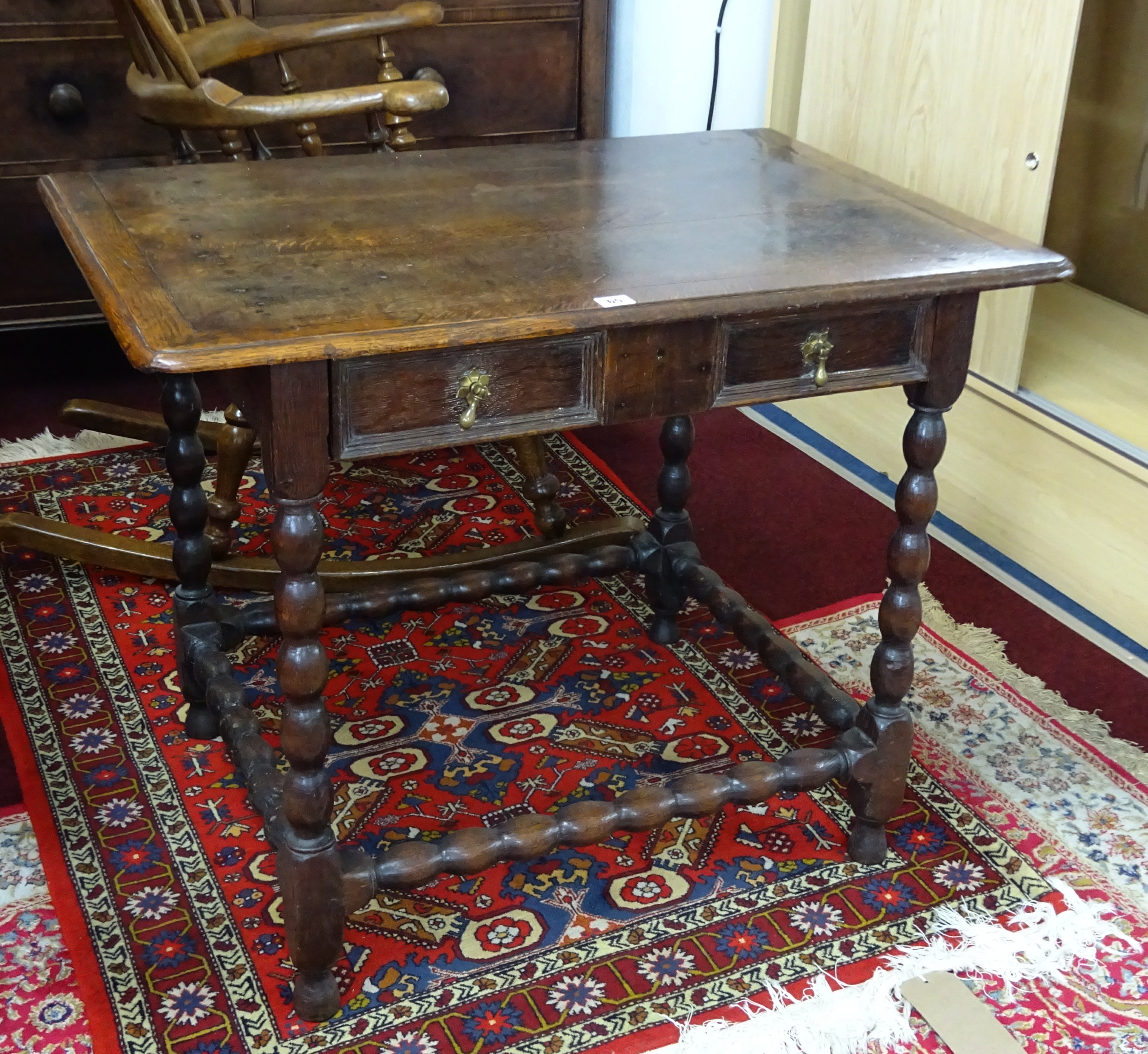 An antique joined oak side table, fitted with a single drawer with pear drop handles, three plank