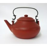 A Yixing teapot of squat form, with brass handle, height 10cm, impressed marks.