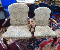 A pair of mahogany framed elbow chairs with upholstered seats and backs of Georgian design.