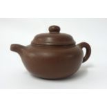 A Yixing small dark brown, plain teapot of squat form, height 7cm.