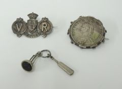 A Victorian Jubilee crown 1897, mounted as a brooch, another Victorian Jubilee brooch, and a novelty